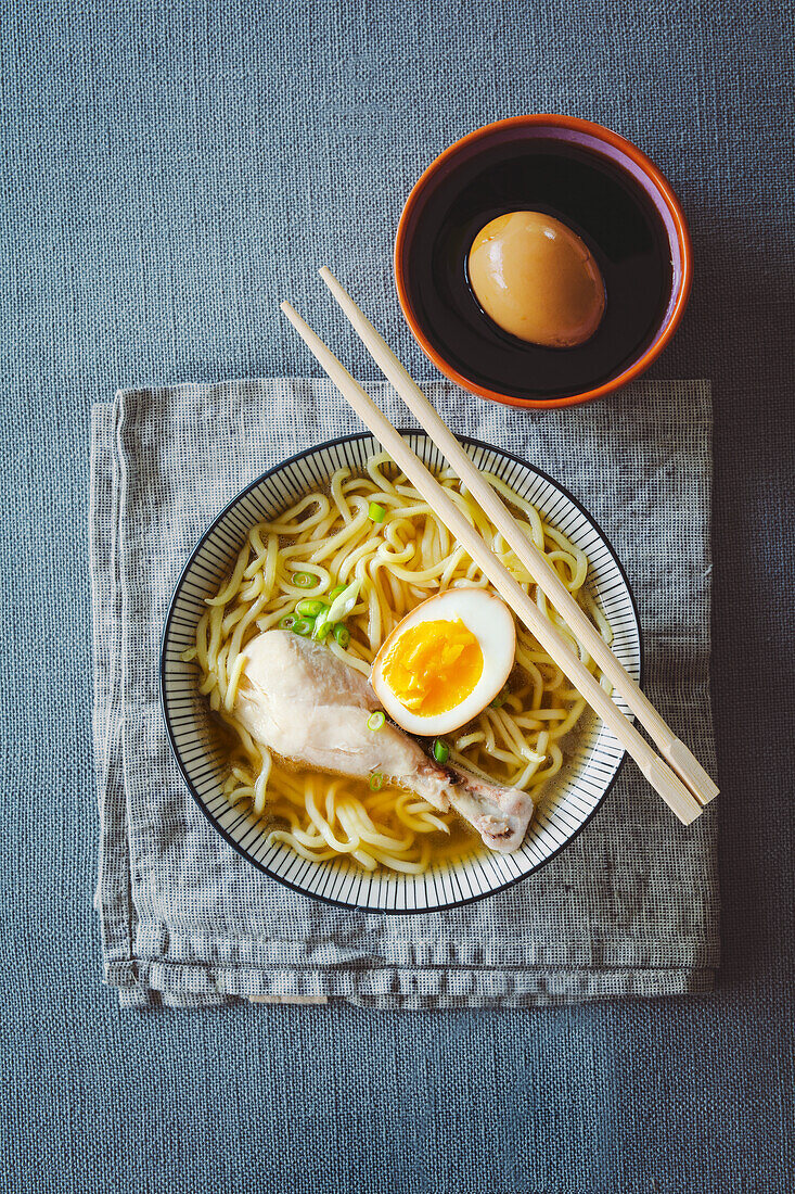 Japanese udon noodle soup with a chicken drumstick and an egg marinated in soy sauce