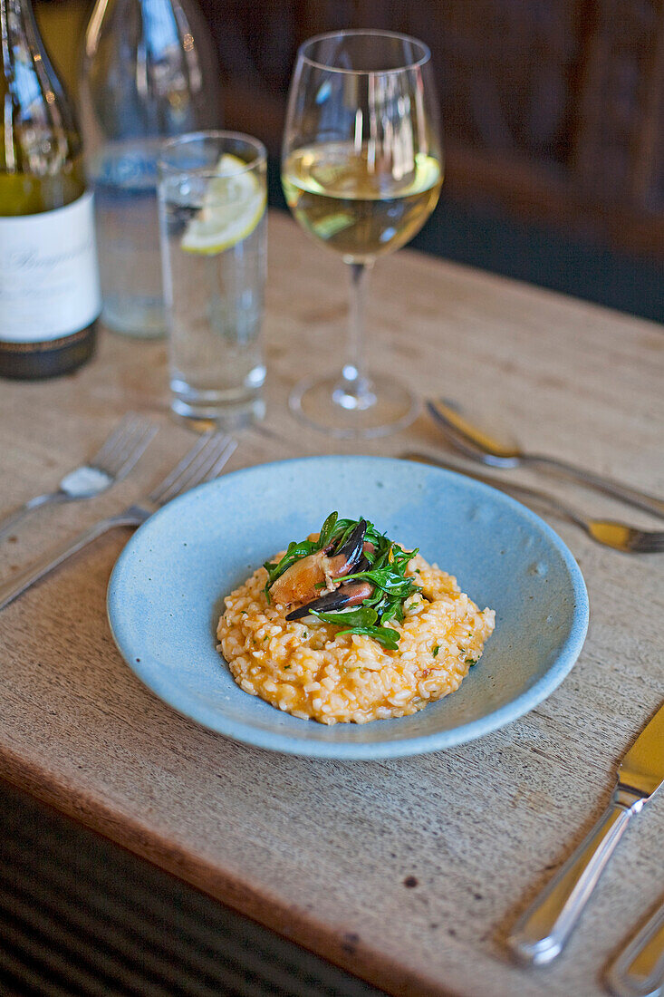 Crab risotto with purslane on a rustic wooden table