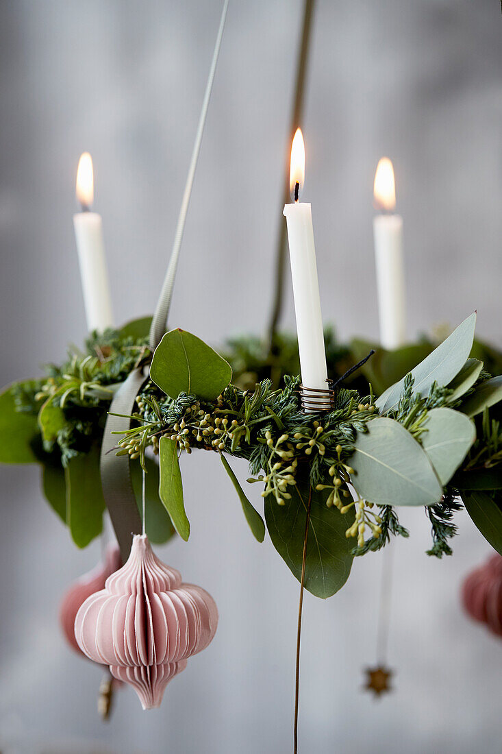 Suspended Advent wreath made of leaves decorated with a honeycomb paper ball