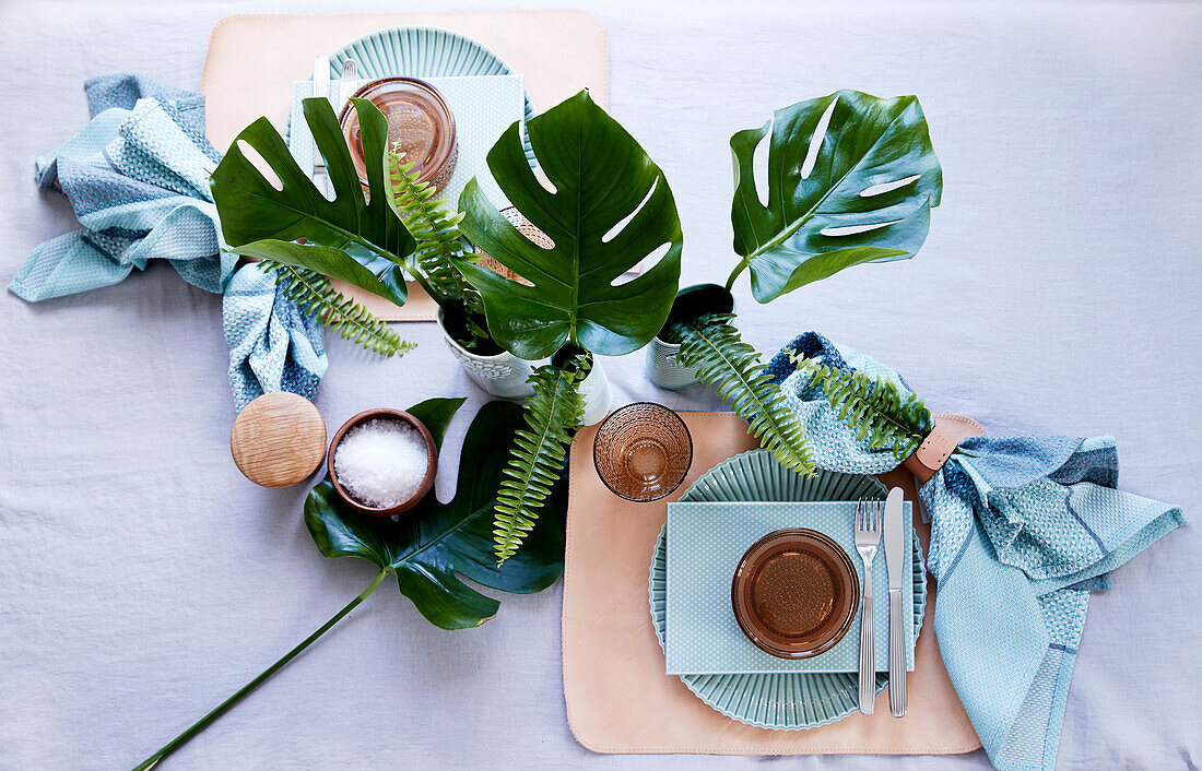 Gedeckter Tisch für Zwei mit Monstera und Farn dekoriert