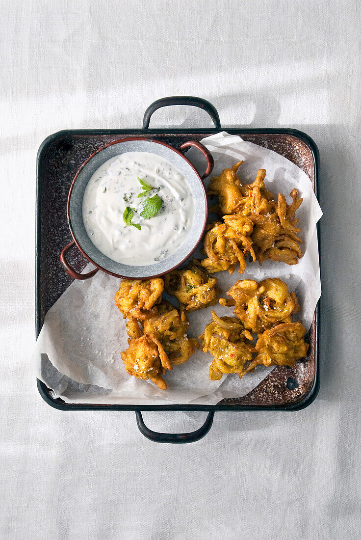 Red onion and chili bhajis with raita of mint and garlic