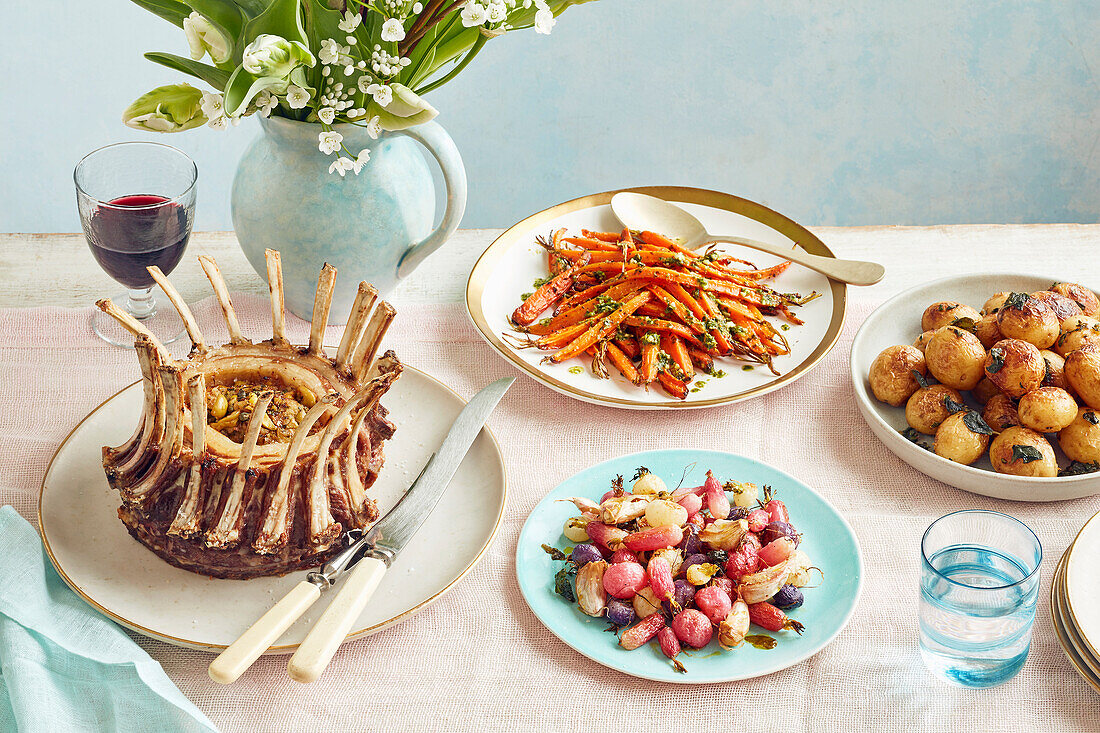Lammkrone mit Sardellen- und Kapernfüllung, Kräuter-Frühkartoffeln, geröstete Radieschen und Karotten