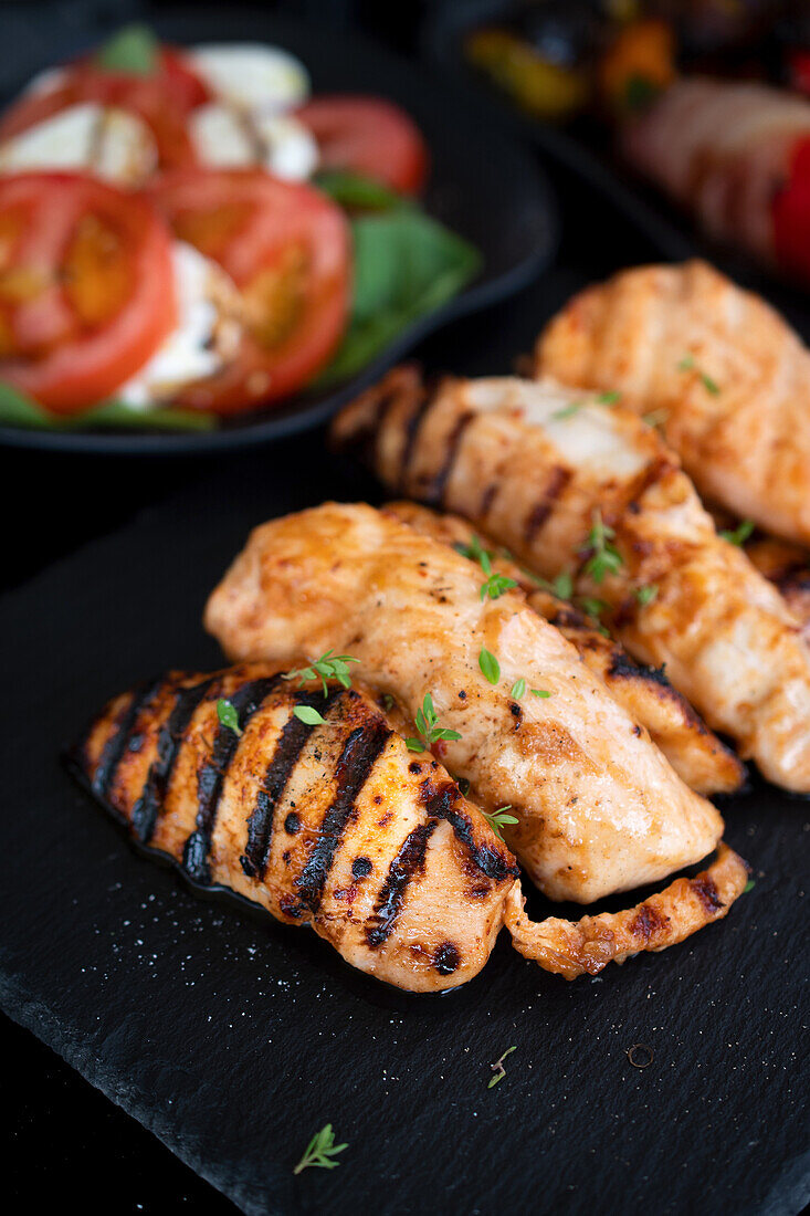 Grilled chicken breast served with tomatoes and mozzarella cheese