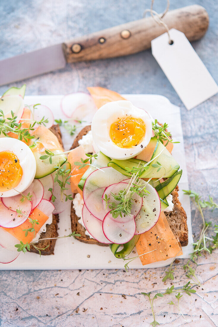 Summer vegetable carpaccio on bread with cream cheese, cress and egg