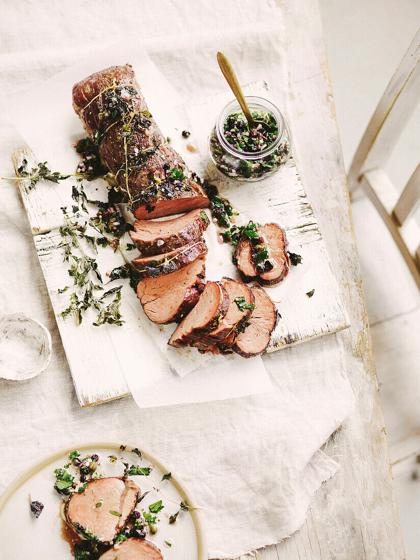 Slow-roasted beef fillet with currants, anchovies, garlic and herbs