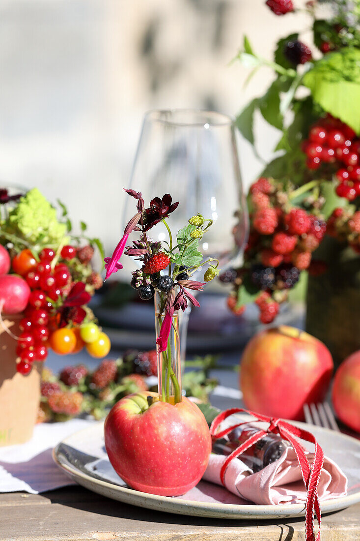 Dekoratives Reagenzgläschen im Apfel als Tischdeko