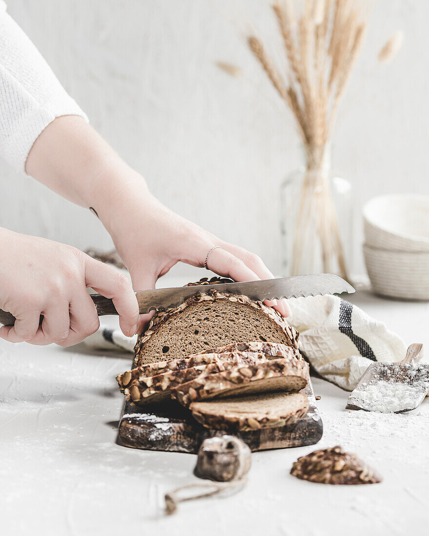 Mustard crust bread being cut by hand