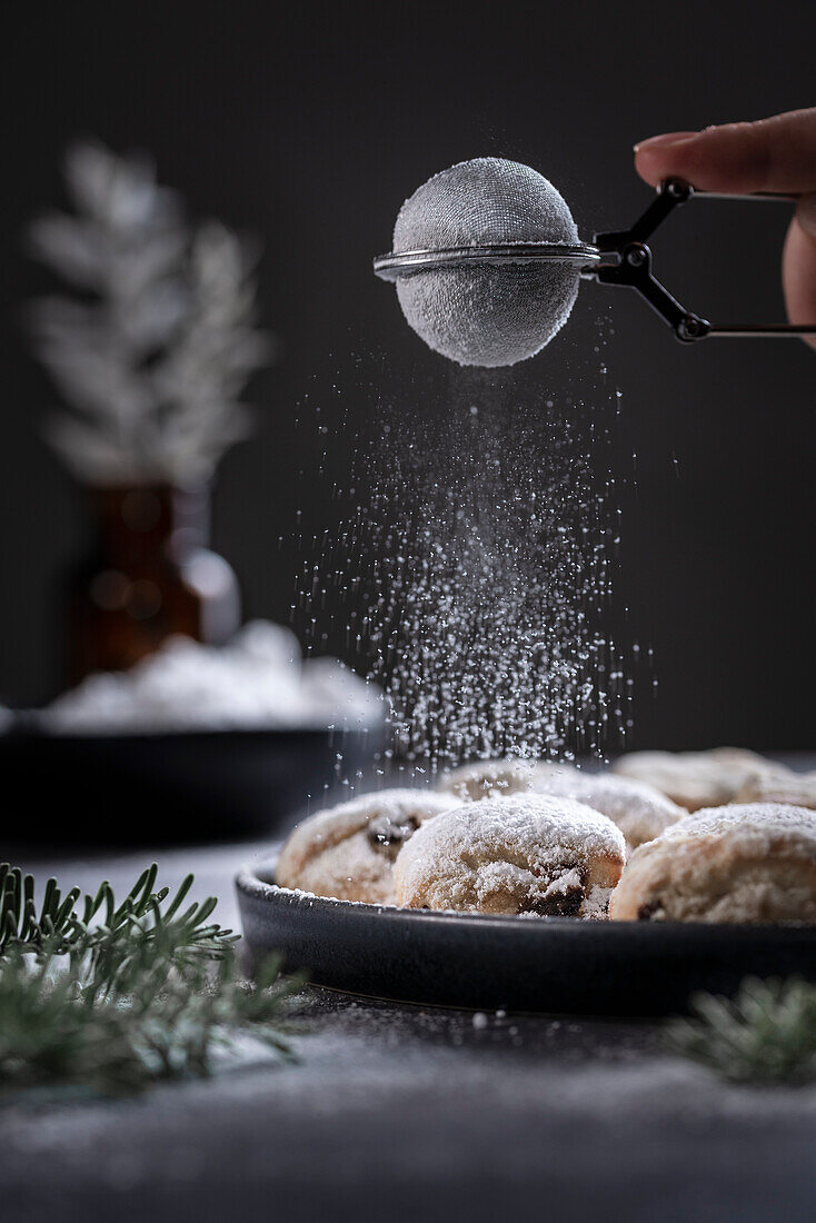 Stollen bites being dusted with icing sugar