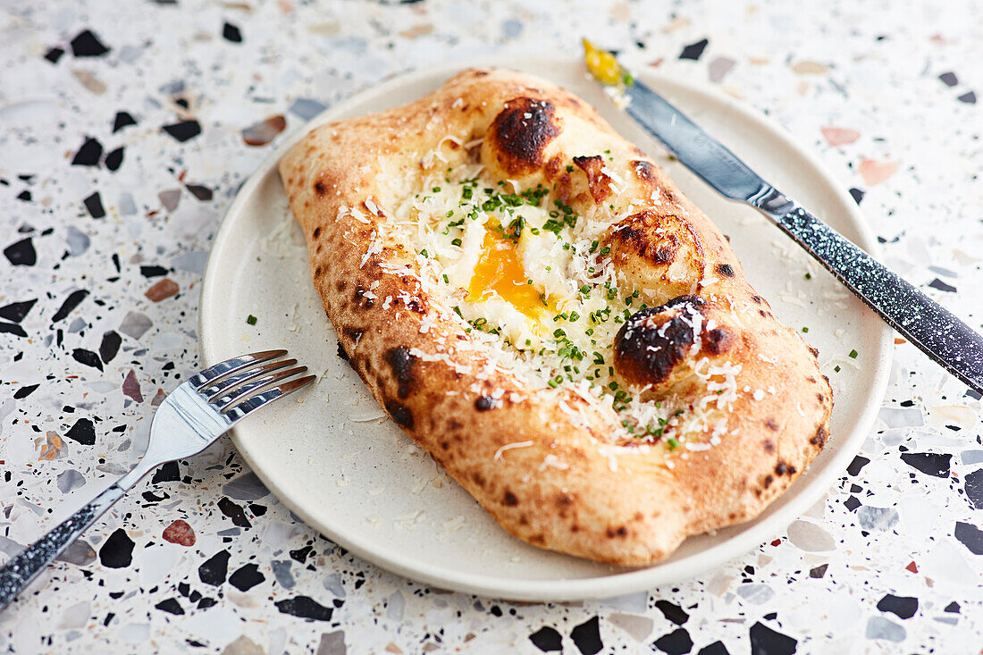 Käsiges pochiertes Ei auf gebackenem Brot mit Schnittlauch