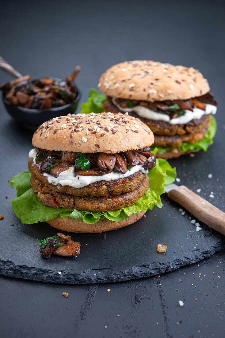 Lentil and spinach patties with roasted wild mushrooms, salad and remoulade in a multigrain bun (vegan)