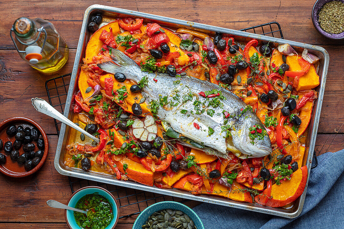 Baked gilthead with pumpkin, peppers, tomatoes, and olives