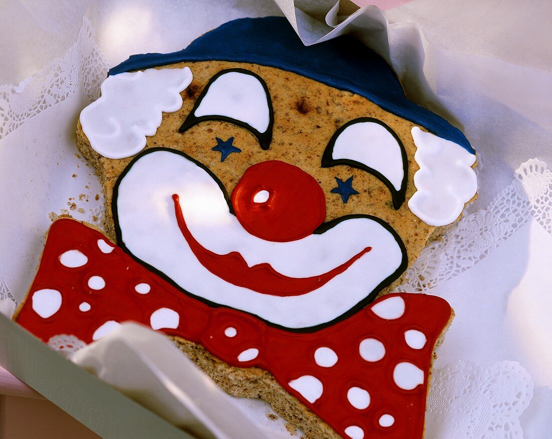 Baked clown's face in nut dough with coloured icing