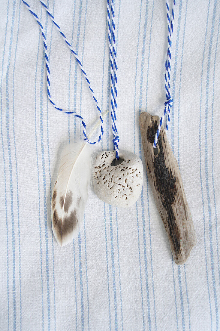 Maritime decoration made of driftwood, feather and stone with string