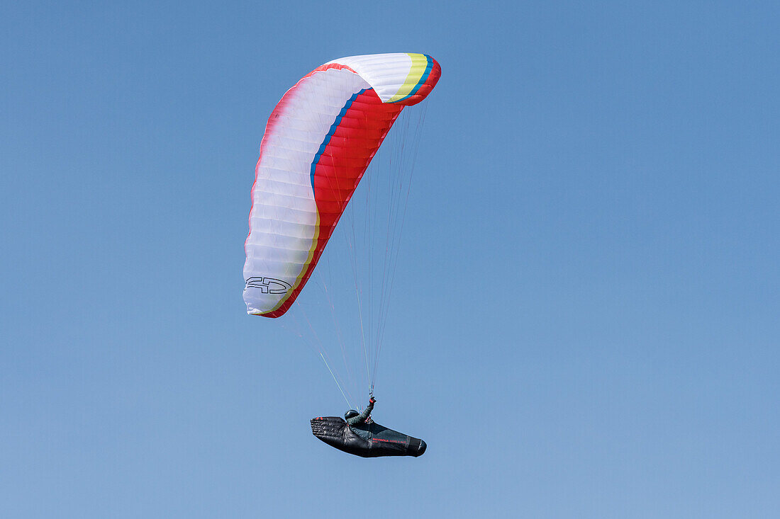 Paraglider pilot flying in an aerodynamic fairing harness