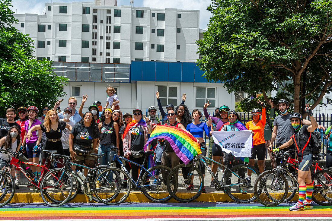 Group of cyclists next to rainbow flag bike lane