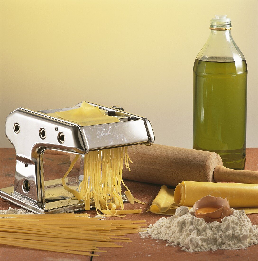Pasta machine with pasta dough, pasta, ingredients, rolling pin