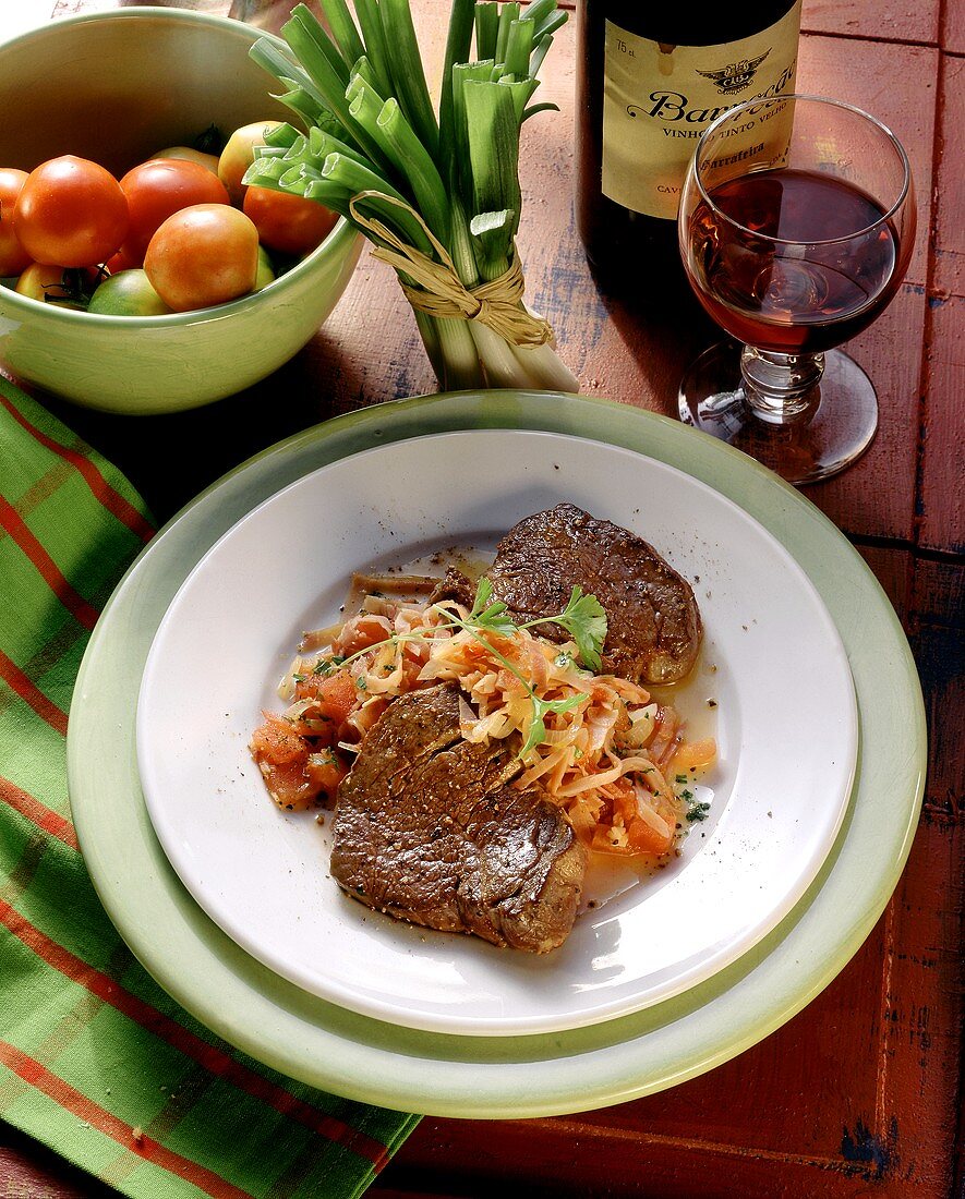 Fillet steaks with tomato & onion casserole on plate
