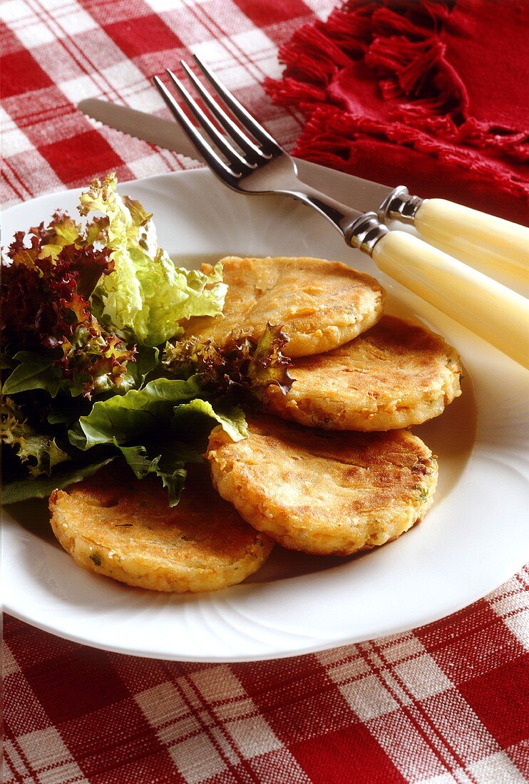 Karotten-Sellerie-Bratlinge mit Blattsalat auf Teller