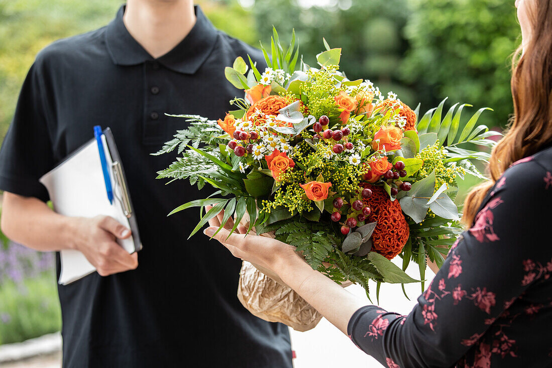 Delivery service - supplier hands over bouquet of flowers