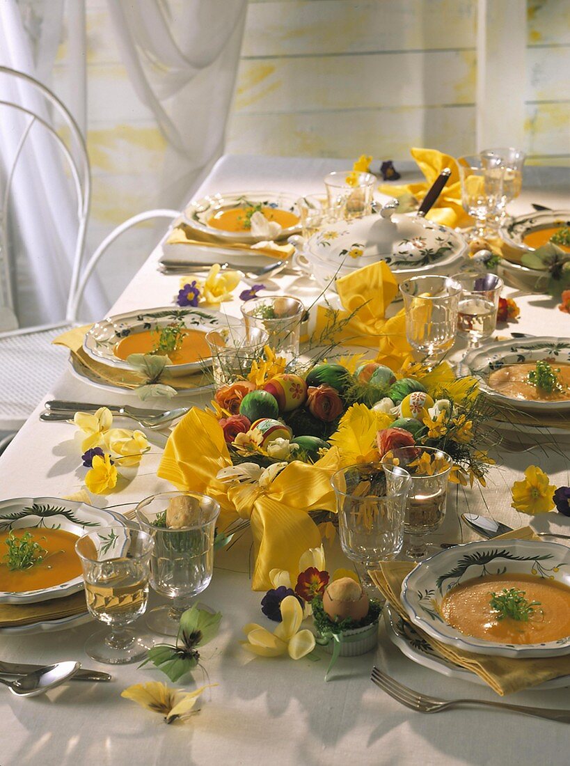 Easter table with carrot soup in plates, Easter wreath