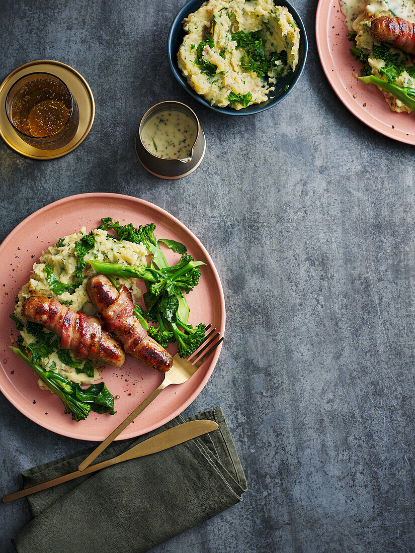 Sausages wrapped in bacon and colcannon