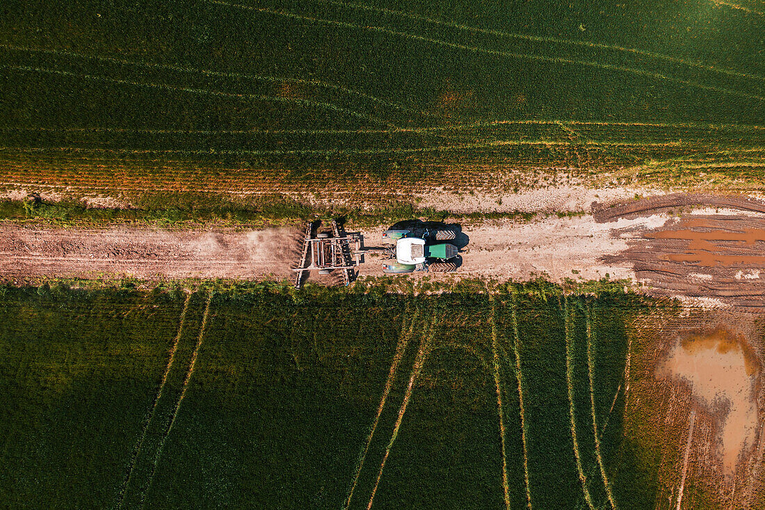 Aerial view of agricultural tractor with tiller attached