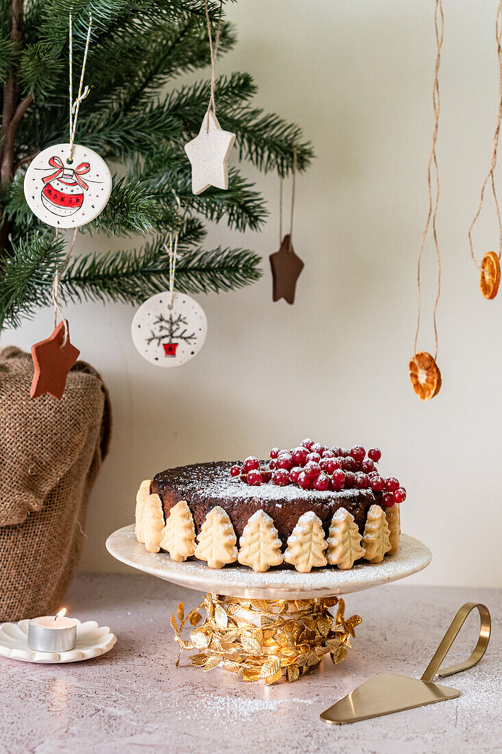 Weihnachts-Früchtekuchen dekoriert mit Mürbteigbäumen und Johannisbeeren