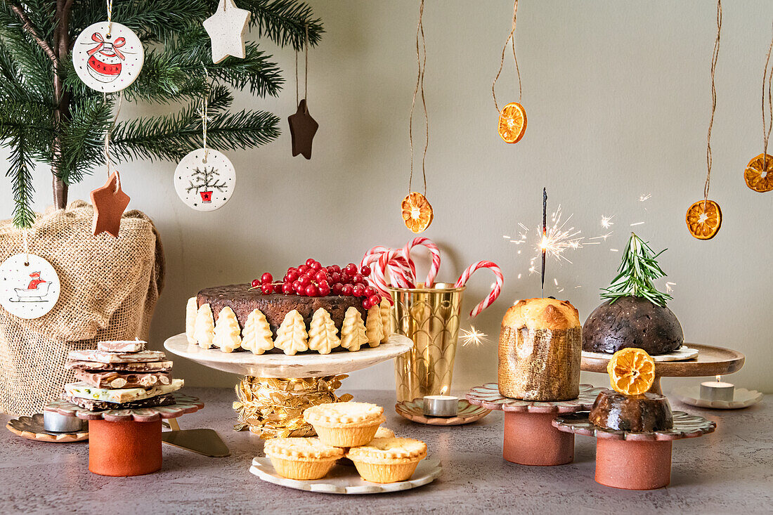 Sweet Christmas buffet with chocolate, fruit cake, mince pies, panettone, Christmas pudding and candy canes