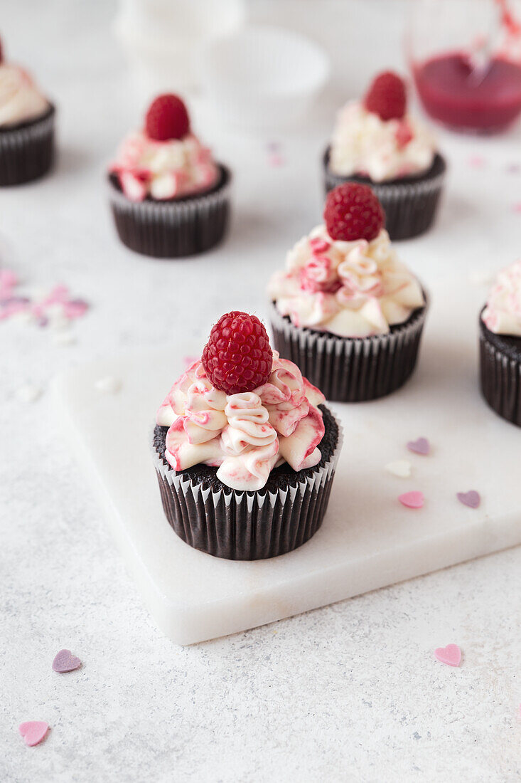 Chocolate cupcakes with raspberry frosting and fresh raspberries