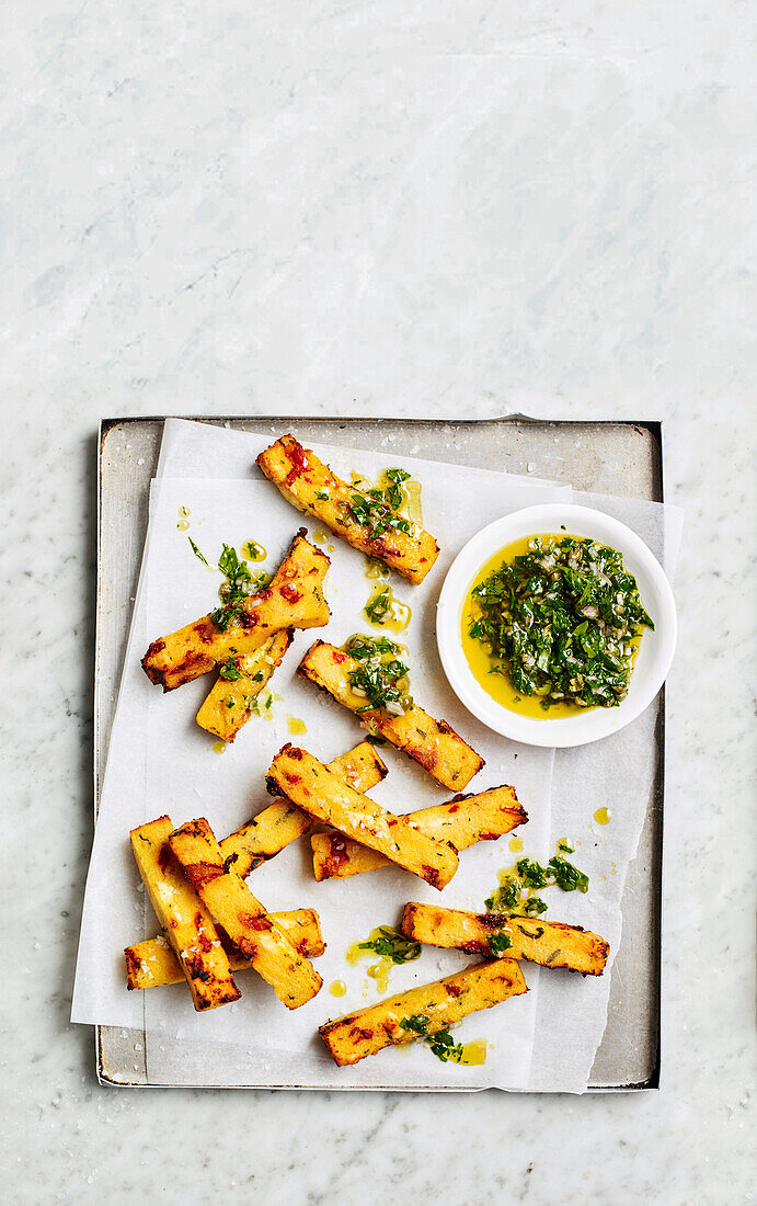 Polenta fries with sun-dried tomatoes, feta and herb oil