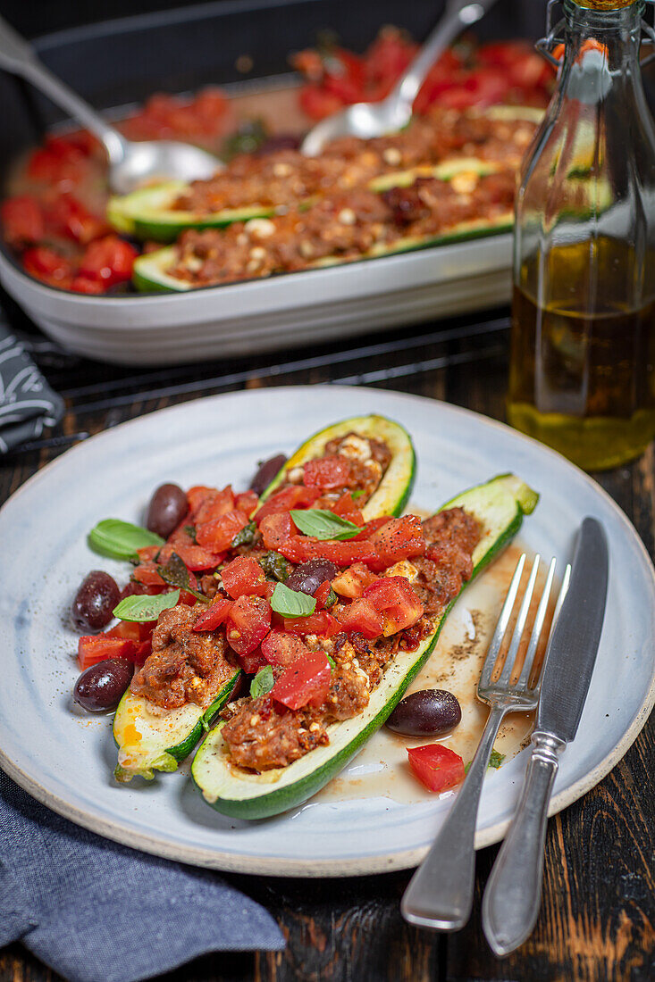 Courgettes stuffed with chicken and feta, baked with fresh tomatoes