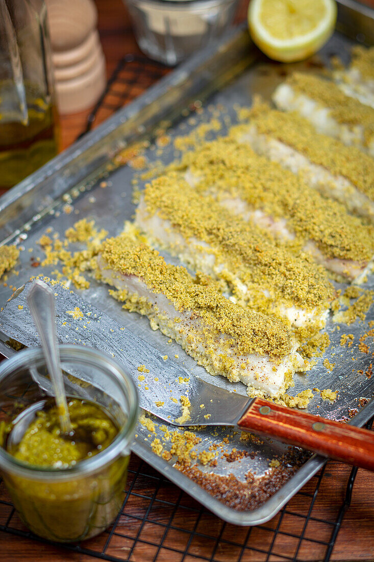 Fish fillet with herb crust on baking tray
