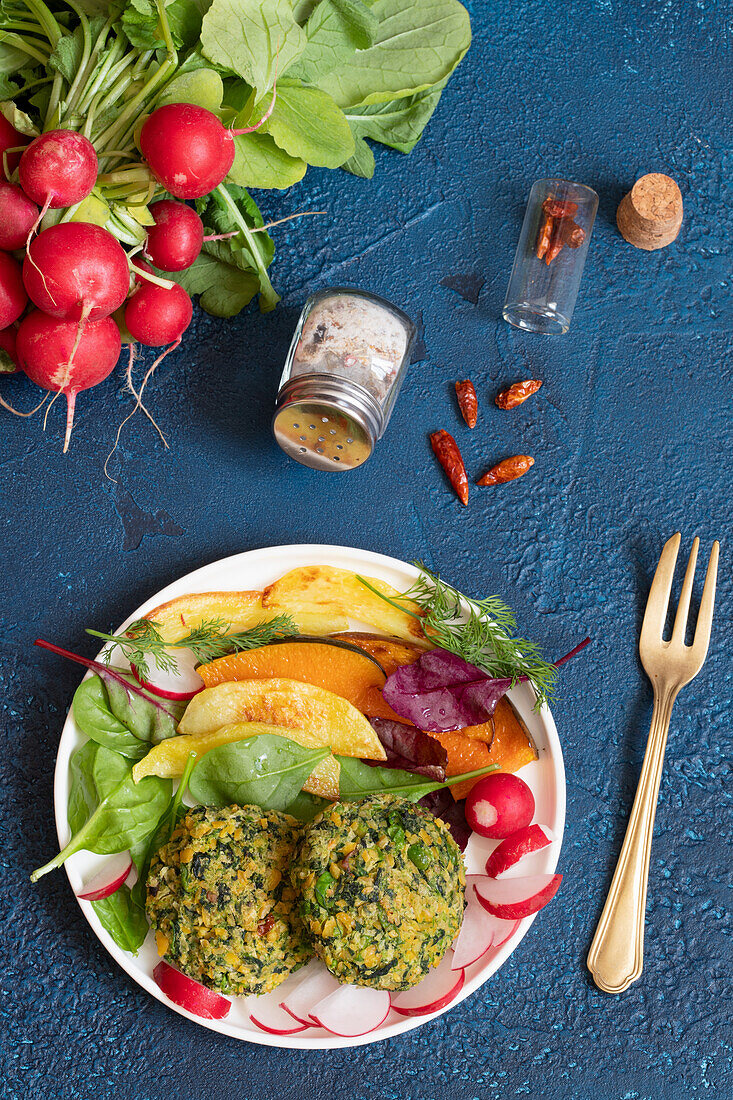 Chickpea falafel with peas and spinach served with pumpkin vegetables, potatoes and radishes
