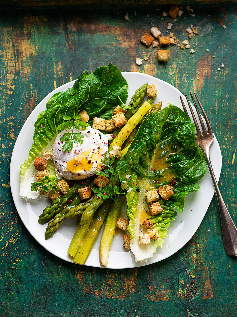 Lukewarm asparagus salad with poached egg and croutons