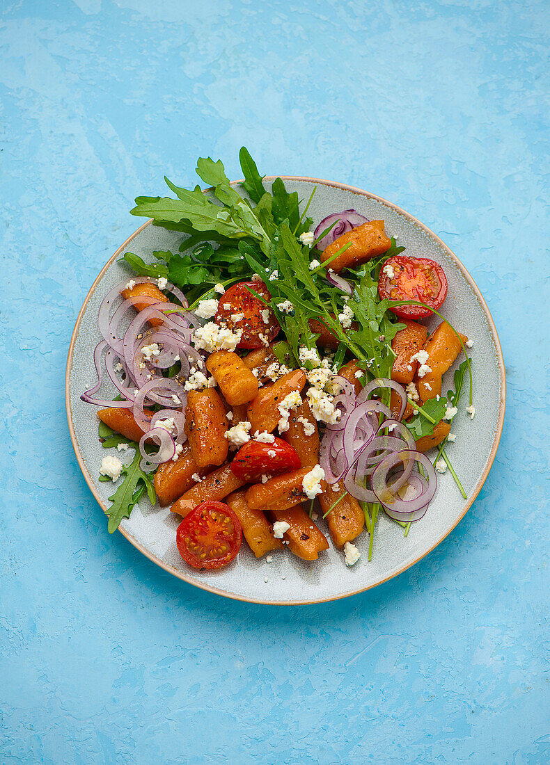 Süßkartoffel-Gnocchi Salat mit Feta, Rucola und roten Zwiebeln