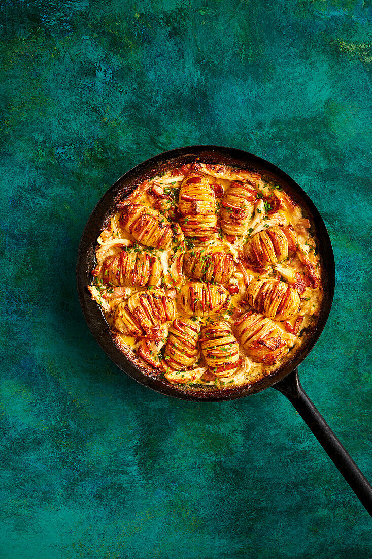 Hasselback potatoes with bacon on a creamy chicken ragout