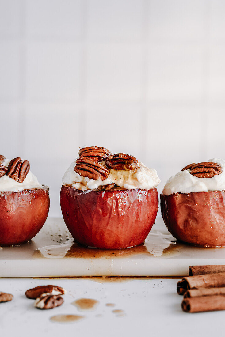 Baked apples with nut filling, garnished with cream and maple syrup