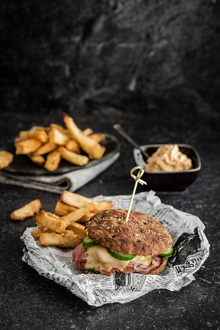 Rustikaler Cheeseburger mit Pastrami und Pommes