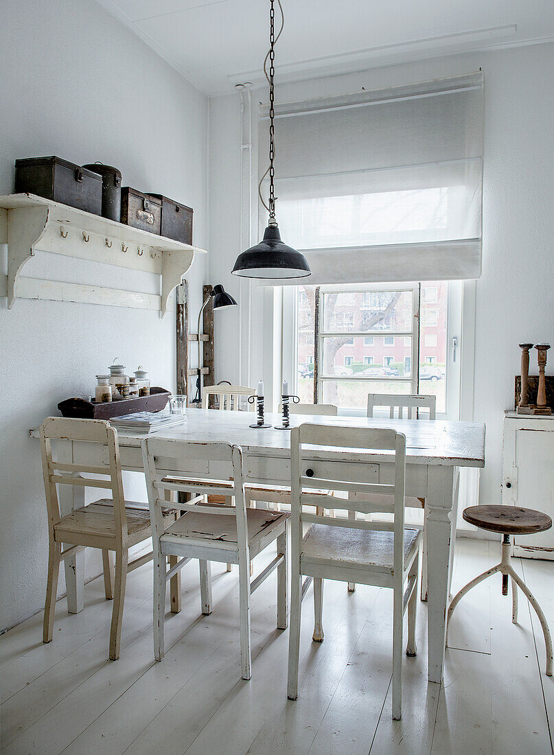 Bright dining room with white wooden furniture and metal lamp