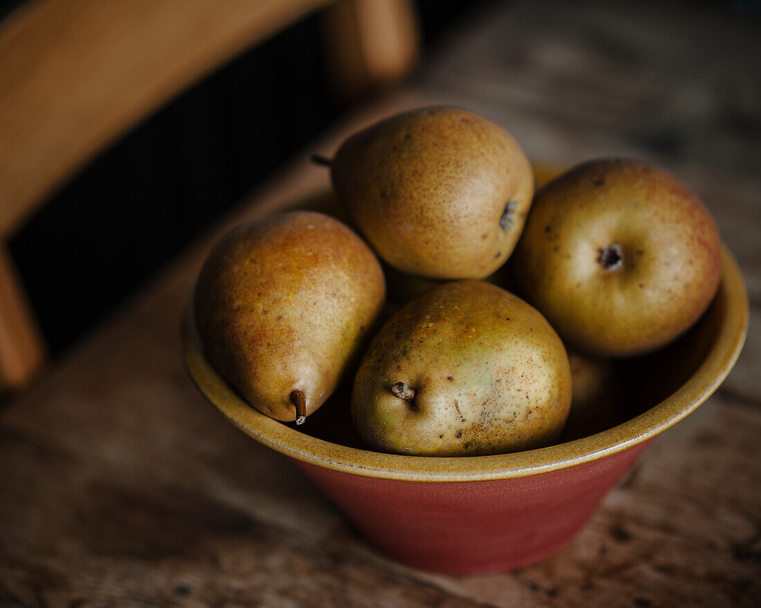 Comice pears in a rustic terracotta bowl