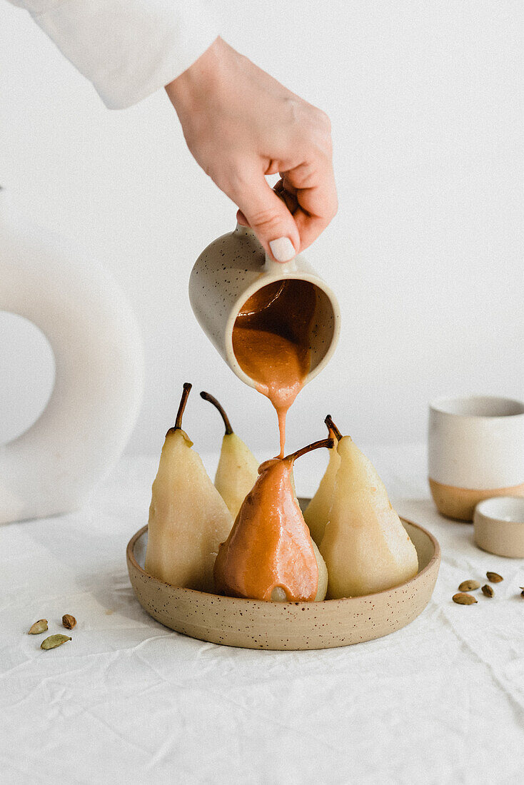 Poached pears are doused with peanut sauce
