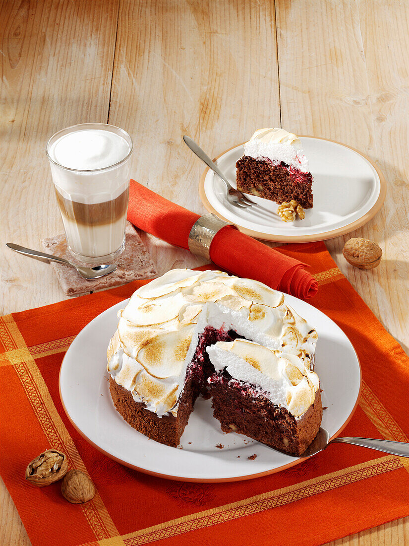 Fruity chocolate and cherry cake with nuts and meringue topping