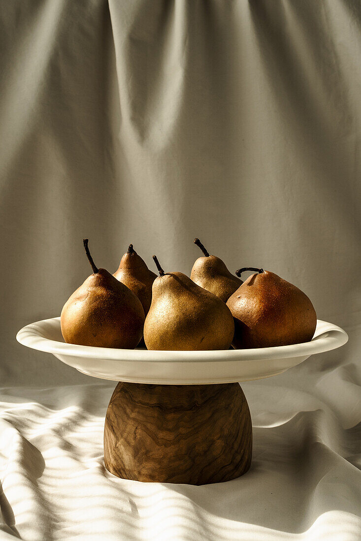 Pear on plate against beige background