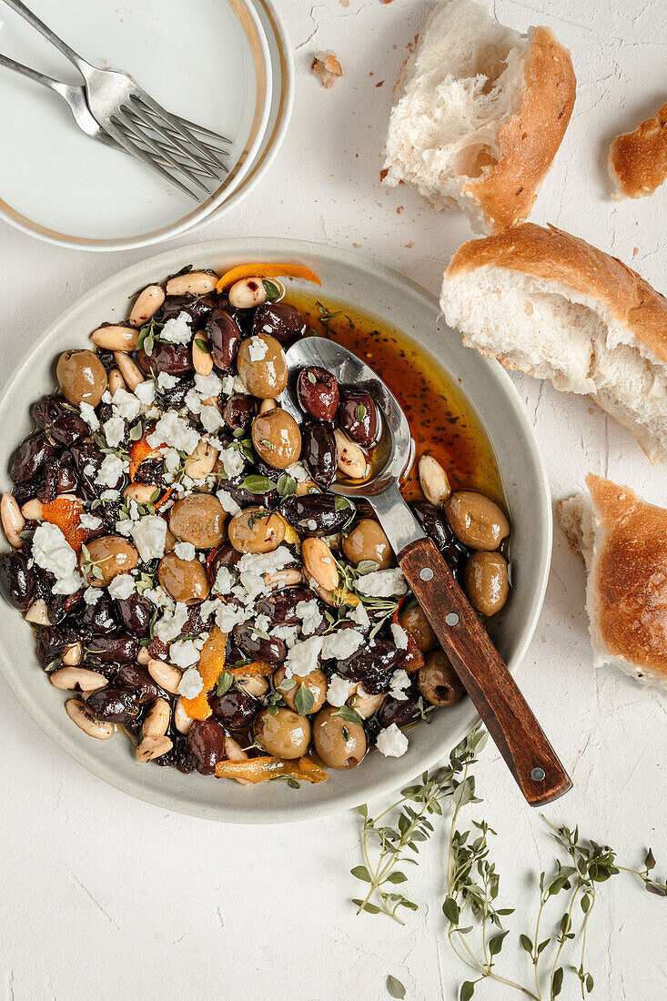 Sweet and sour marinated olives with feta, fresh thyme and white bread
