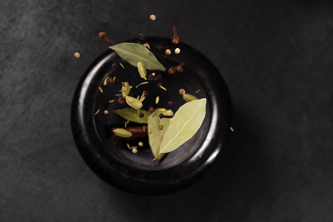 Herbs and spices on a black plate