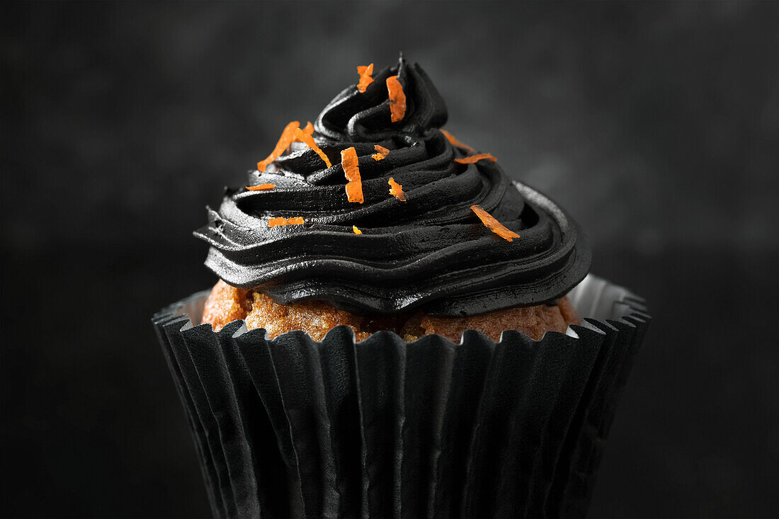 Halloween-Cupcake mit schwarzer Buttercreme und Orangenzesten