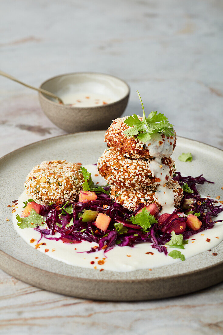 Vegan chickpea and sesame falafel on a mango and red cabbage salad