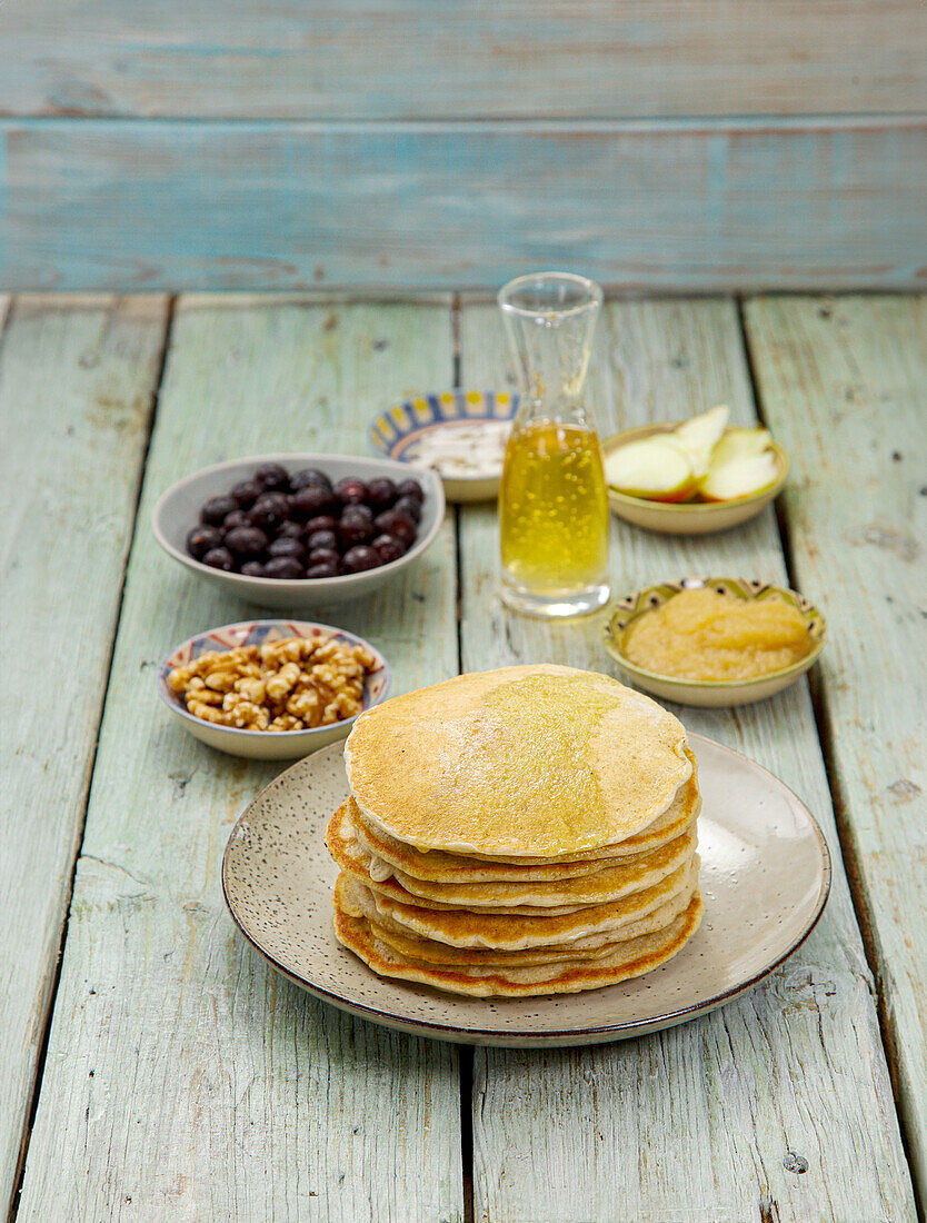 Bananen-Pancakes auf Teller gestapelt mit Topping-Zutaten