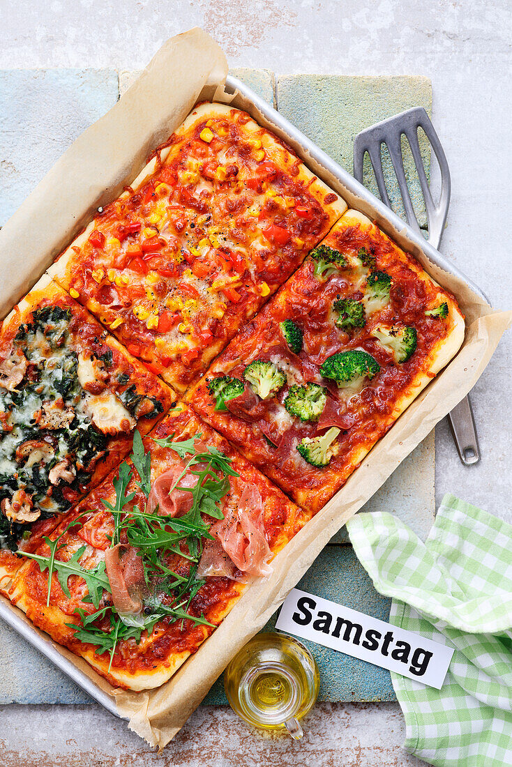 Family pizza from the tray with four different toppings