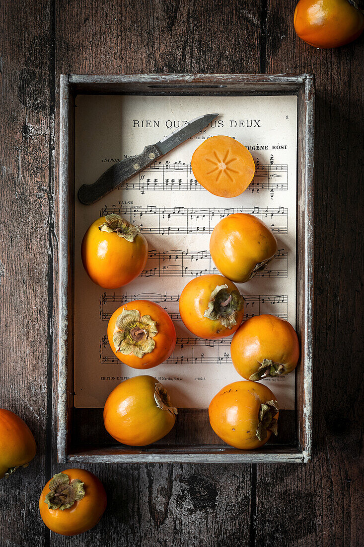 Persimmons in a wooden tray